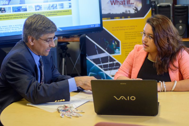 Dr. Panchanathan discusses a research project with a student while sitting at a table