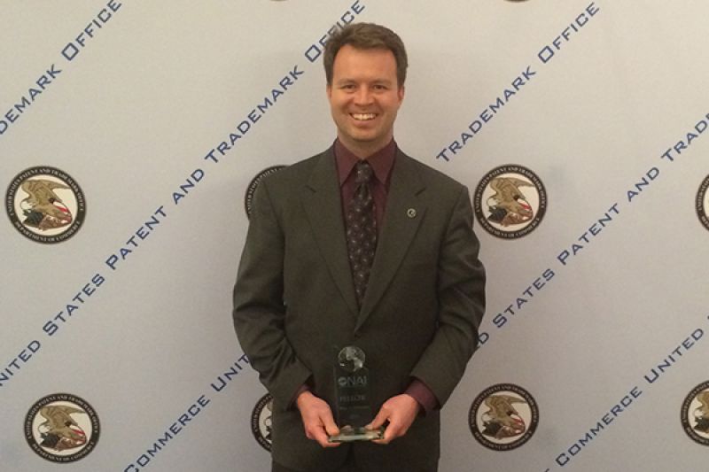 Wayne Westerman smiles while holding an award