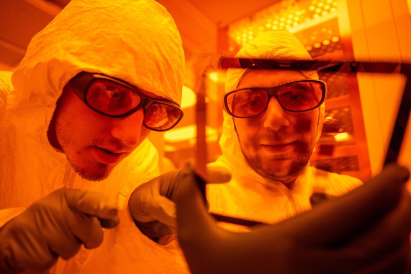 Two researchers in a lab wearing protective lab gear