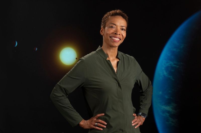 woman standing in front of a backdrop with solar system
