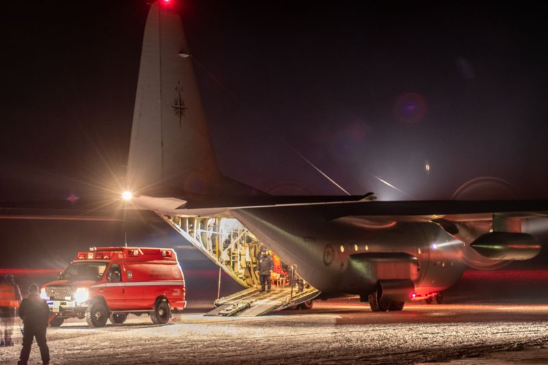 an airplane with a medical van next to it