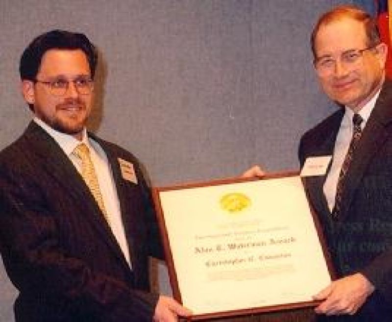 Dr. Christopher C. Cummins and Neal Lane, NSF Director holding framed plaque award