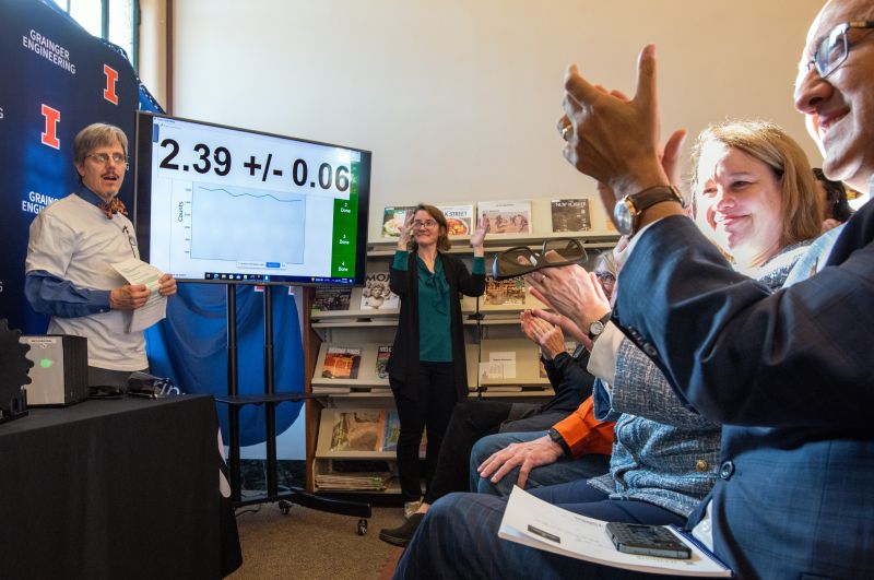 The positive result of a test for entanglement of photons travelling through The Urbana Free Library and photons at the University of Illinois Urbana-Champaign (UIUC) is displayed at the Public Quantum Network launch event. From left to right: UIUC professor Paul Kwiat, American Sign Language Interpreter Heidi Johnson, Vice Chancellor for Research and Innovation at UIUC Susan Martinis, and Dean of the Grainger College of Engineering at UIUC Rashid Bashir.