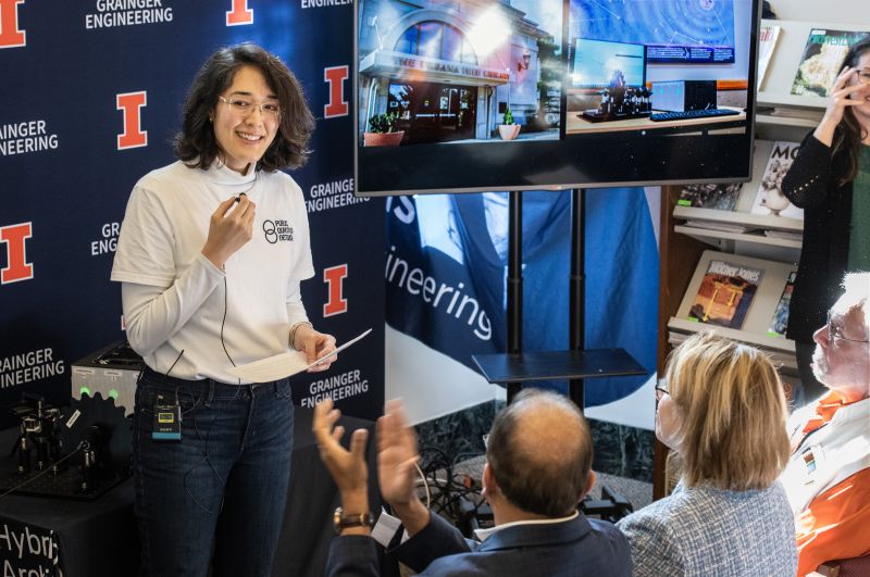 woman giving standing in front of group of people taliing
