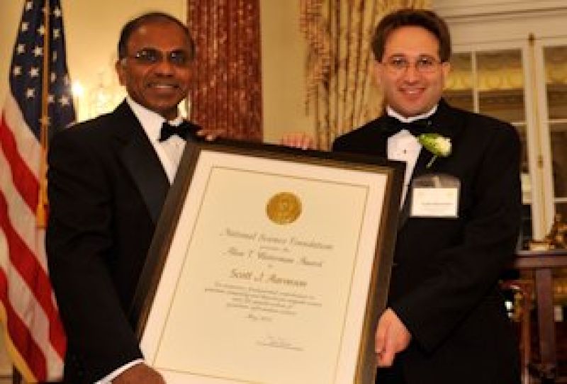 Subra Suresh, NSF Director holding a frame with Waterman Award winner Scott J. Aaronson, both wearing suit and bow ties