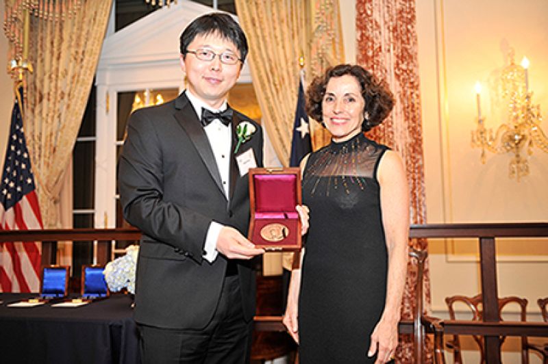 Feng Zhang with France Córdova, NSF Director holding an award