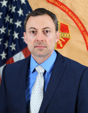 portrait of courtesy of Alfredo Riera wearing a suit and tie