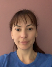 portrait of Alina Pavao with bangs and wearing a blue shirt