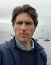 portrait of Chris McCarthy with light brown hair and wearing a blue jacket