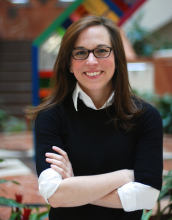 portrait of Margaret Benoit medium length brown hair, wearing glasses, in a black sweater