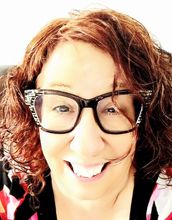 portrait of Nancy Carey with curly hair and wearing glasses