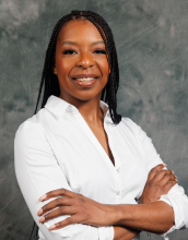 portrait of Rasheda Spratley with black braided hair wearing a white long sleeve collar shirt