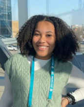 portrait of Taiylor Russell with curly black hair wearing a green shirt