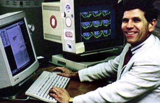 Acting NSF director Kelvin Droegemeier sits at an early supercomputer known as Cray-1 located at NCAR.