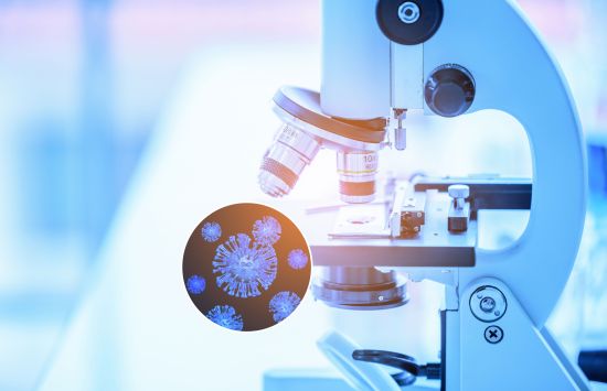 A microscope is shown with a cutaway to a illustration of the SARS-COVID-2 virus