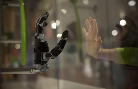 robot hand reaching out to touch a human hand