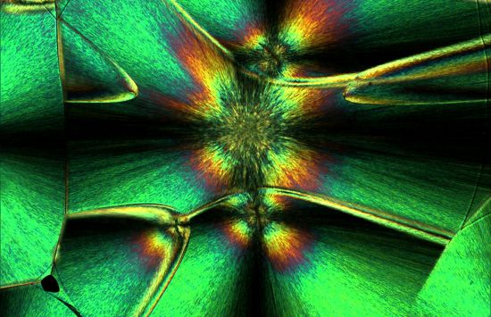 Like raindrops crystallizing into snowflakes as they fall, some polymers can crystallize in a similar way, starting from a central point and growing outwards in all directions. They are like spheres of crystals and, hence, are called spherulites. To fill space, they grow into each other forming the polyhedrons (multi-sided figures) that you see. If you look at the crystal in a polarizing microscope, the Maltese cross pattern is seen. 