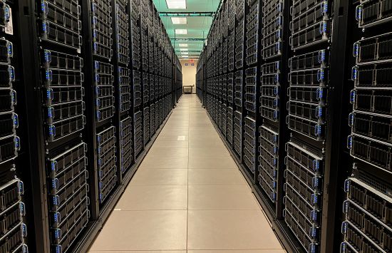 A hallway flanked by stacks of supercomputer servers.