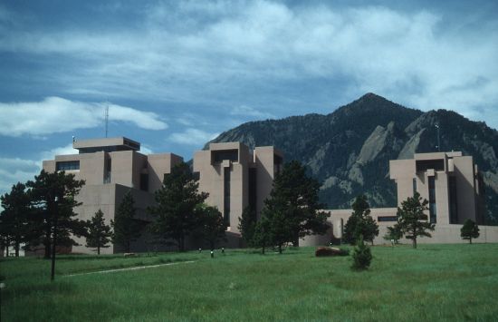 Futuristic geometric buildings with mountains in the background