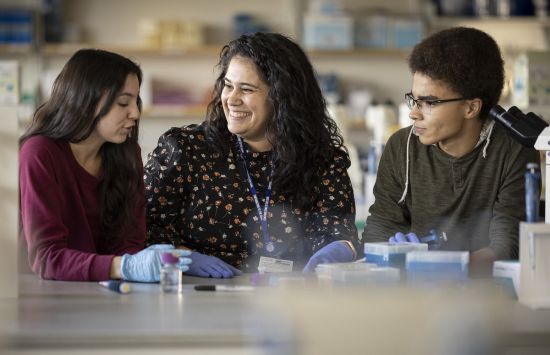 A professor in a lab with two students