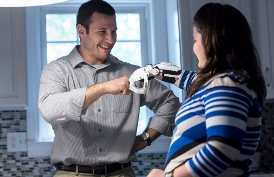 A woman with a prosthetic hand fist-bumps a man.