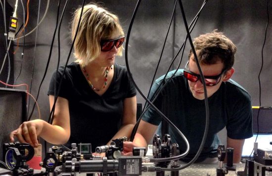 Two researchers wearing protective eyewear stand at a laboratory set-up