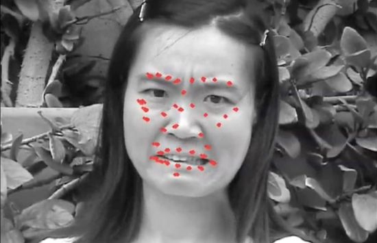 A black-and-white photo of a frowning face overlaid with red dots surrounding the eyes and mouth.