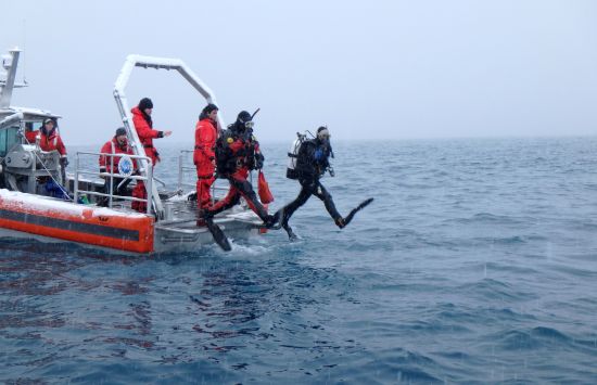 Scientific divers, Chuck Amsler (left, in red) and Sabrina Heiser (right, in black) enter the water from the Rigil, a Rigid Hull Inflatable Boat (RHIB) used at NSF Palmer Station.