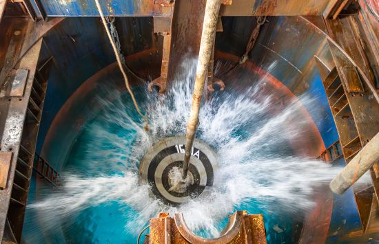 Water splashing onto a circular surface with concentric black, gray and blue circles.