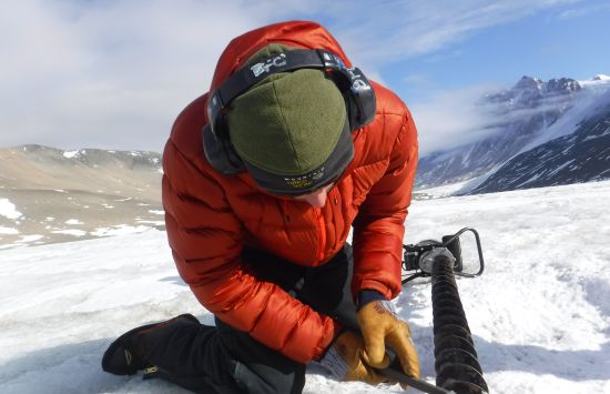 A Long Term Ecological Research (LTER) scientist works on an ice auger before drilling into the ice.