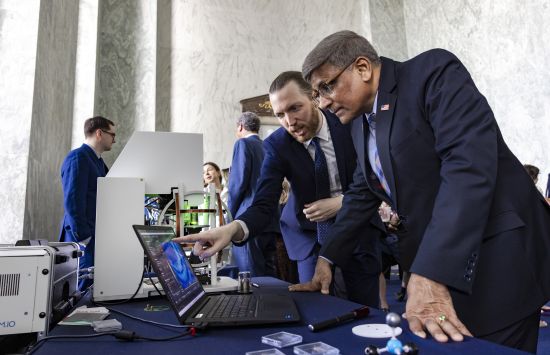 Two participants discuss quantum research at an outreach event.