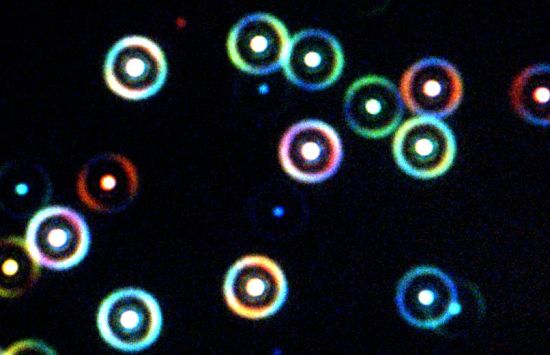 Glowing multicolored target shapes on a black background.