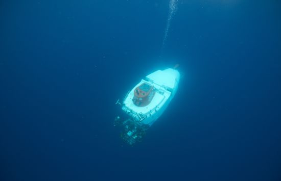 A small submersible is surrounded by the uniform blue of the open ocean.