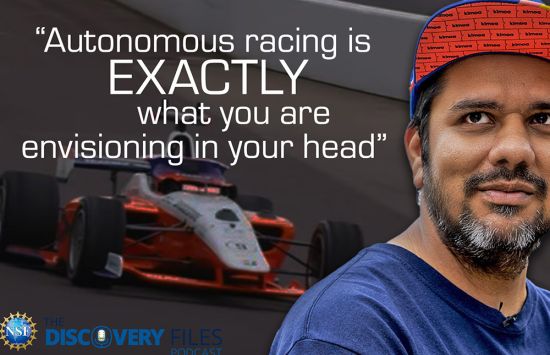 A man with a red hat with a red race car in the background.