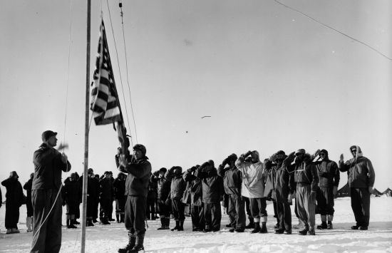 Men at Little America IV, saluting the U.S. flag.