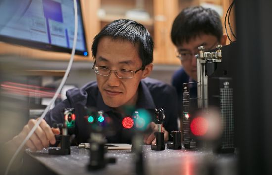 professor working on a laser with student