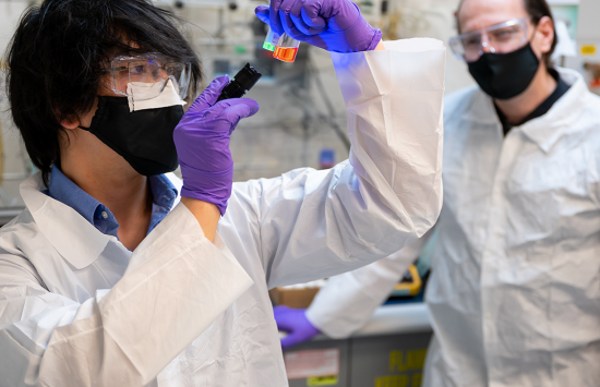 Two scientists looking at fluorescent quantum dot nanoparticles