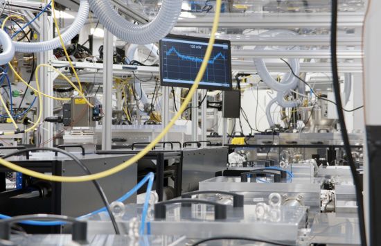 A lab with a computer monitor surrounded by wires and tubing hanging from the ceiling.