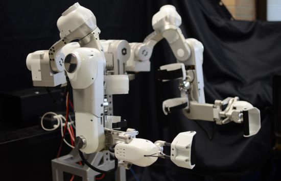 A white and gray device with two robotic arms.