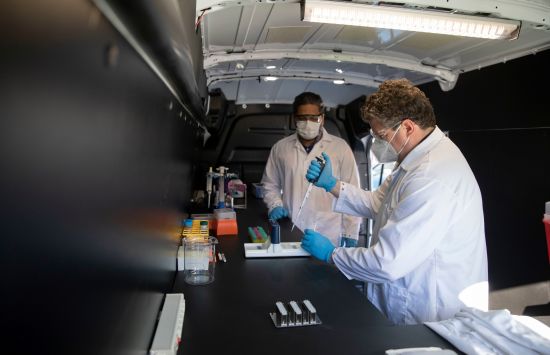 UK researchers Soroosh Torabi and Scott Berry in the "Disease Detectives" mobile lab in February 2022.