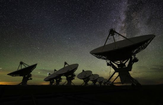 Silhouettes of radio receivers at night.