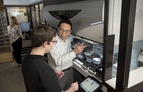 Huimin Zhao, Steve Lane, and Emily Gaither standing in front of the NSF Illinois Biological Foundry for Advanced Biomanufacturing (iBioFAB) at the University of Illinois Urbana-Champaign