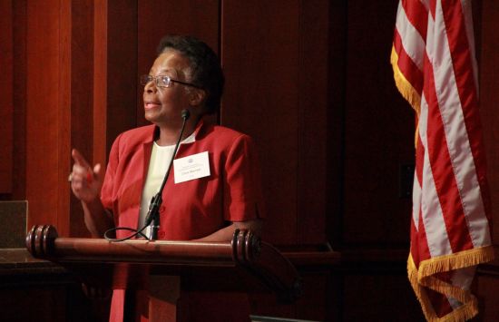 Cora Marrett speaking at a podium - a US flag in the background