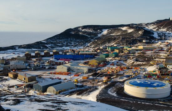 A cluster of buildings on a stark, snow-covered landscape