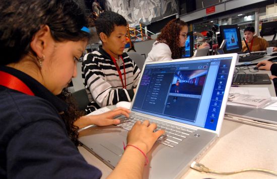 A group of students in a classroom sitting at laptops.