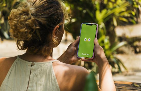 A woman using the Duolingo app on her smartphone