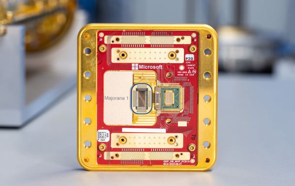 A gold and red rectangular computer chip with many small wires and other electronic components.