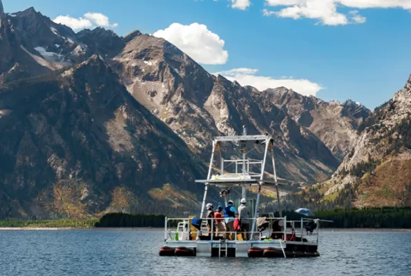 a boat in a body of water with a mountain background