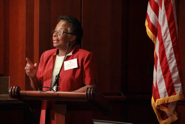 Cora Marrett speaking at a podium - a US flag in the background