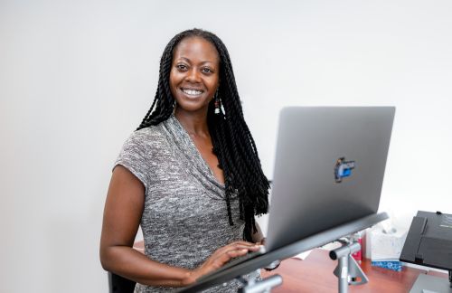 A woman standing in front of a laptop